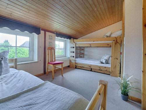 a bedroom with two bunk beds and a chair at Holiday apartment sunrise in Dänschendorf