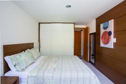 a bedroom with a bed and a wall at Apartamento a 500 m da Praia de Itacoatiara in Niterói