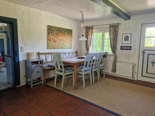 a dining room with a wooden table and chairs at Romantic thatched roof house in Schnarup-Thumby