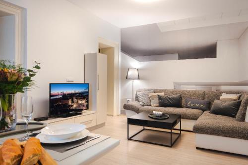 sala de estar con sofá y TV de pantalla plana en Arta Apartment City Center II - with Private Parking, en Pula