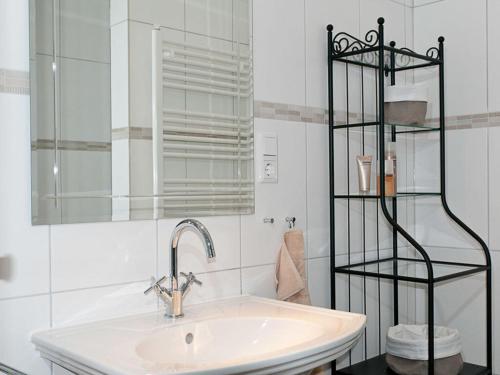 a white bathroom with a sink and a shelf at Casa Schalkenmehren Grande in Schalkenmehren