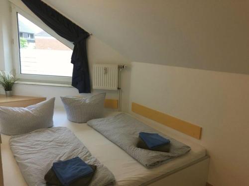 Habitación con 2 camas y almohadas azules. en Holiday apartment wind force 8, en Langeoog