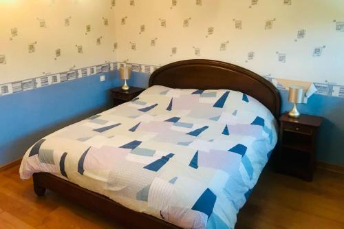 een slaapkamer met een bed met een blauw en wit dekbed bij Maison avec piscine à Névez in Névez