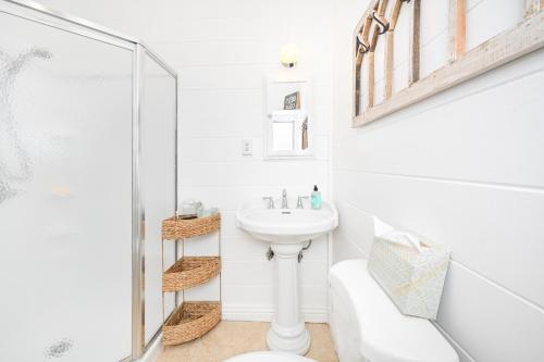 a white bathroom with a sink and a shower at San Clemente Bungalow with jacuzzi Close to the Beach in San Clemente