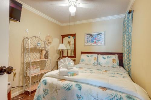 a bedroom with a bed with a blue comforter at Bright Galveston Condo with Balcony and Gulf Views! in Galveston