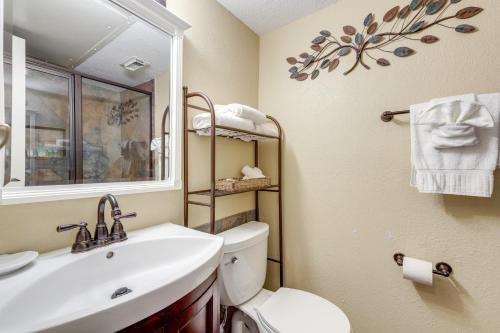 a bathroom with a sink and a toilet and a window at Balcony and Gulf Views Galveston Condo Near Beach in Galveston