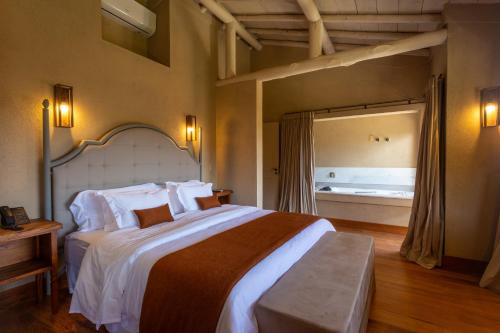 1 dormitorio con 1 cama grande en una habitación en Quinta dos Manacás Pousada - Pedra Azul - Rota dos Lagos en Pedra Azul