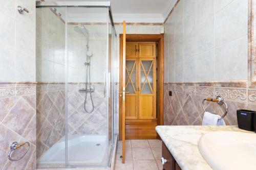 a bathroom with a shower and a tub and a sink at Casa Lali Habitación 2 in Las Lagunas