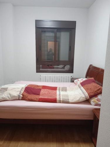 a bed sitting under a window in a bedroom at C.Grafito 22 in Torrejón de Ardoz