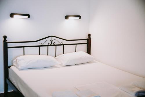 a white bed with two white pillows on it at Villas Gemeli in Ammouliani