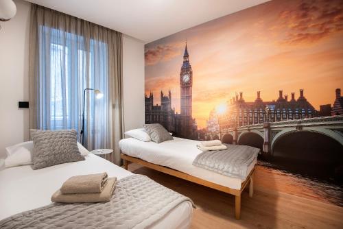 a room with two beds and a mural of big ben at Arta Apartments City Center - with Private Parking in Pula