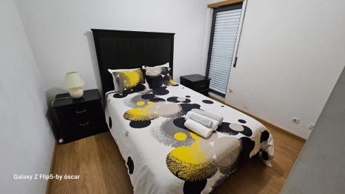 um quarto com uma cama com um edredão preto e amarelo em Ap Central Chic em Odivelas