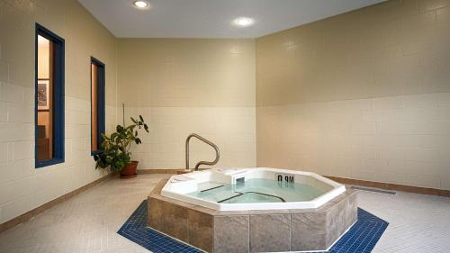Best Western Plus Otonabee Inn في بيتربورو: حمام مع حوض استحمام في الغرفة