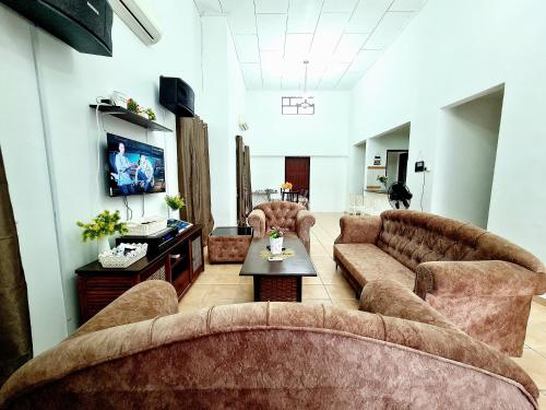 a living room with two couches and a tv at Villa Sampaguita 4bedroom Private Villa in Kampong Alor Gajah