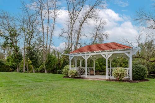a white gazebo with a red roof in a field at Best Western Plus Otonabee Inn in Peterborough