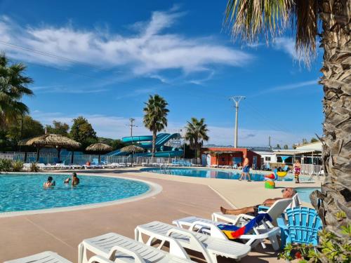- une piscine avec des chaises longues et des personnes dans l'eau dans l'établissement Azur 49, à Fréjus