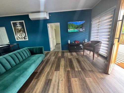 uma sala de estar com um sofá verde e uma mesa em Casa en pichilemu em Pichilemu