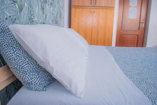 a white pillow sitting on top of a bed at Villa Magnolia con giardino in Bari