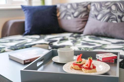 a tray with a plate of food and a cup on a table at Stunning seaside penthouse apartment with balcony in Newlyn