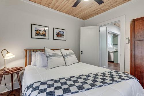 a bedroom with a white bed with a checkered blanket at Modern-Boho Bradenton Bungalow with Private Hot Tub! in Bradenton