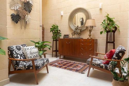 a room with two chairs and a dresser and a mirror at Casa Maria Pia in Nadur