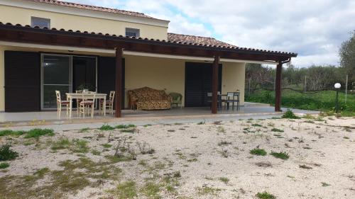 a house with a patio with a table and chairs at Bingo in Alghero