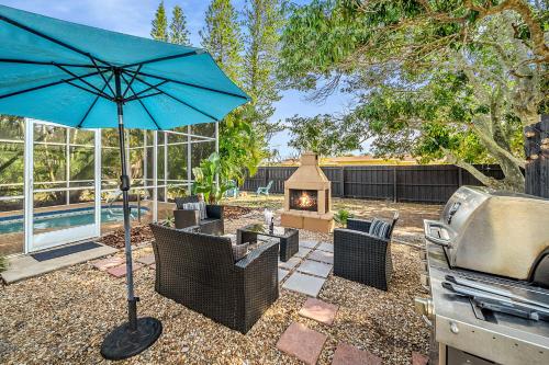 a patio with a grill and an umbrella and a grill at Beachside Bliss 1 miles to the beach with heated pool in Sarasota