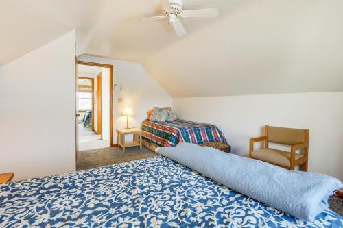 a bedroom with a blue bed and a chair at Waterfront Cottage with Deck and Dock on Dragon Lake! in Fremont