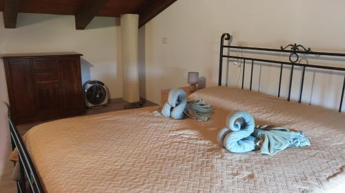 a bed with two blue towels laying on it at Bingo in Alghero