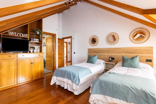 a bedroom with two beds and a flat screen tv at Casa Lali Habitación baño compartido in Las Lagunas