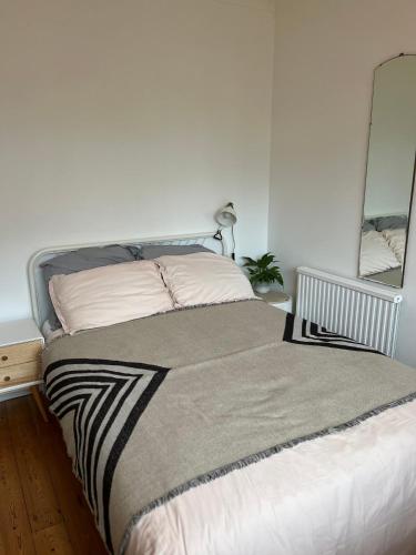 a bed in a white room with a mirror at Saltdean Stay in Brighton & Hove