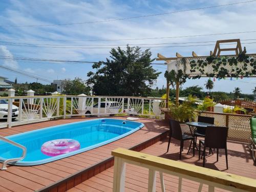 a deck with a swimming pool and a table and chairs at Pryme Paradise in Carnbee Village