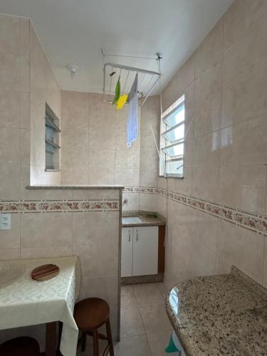 a kitchen with a sink and a table in a room at Apartamento Centro ao lado do Country Club in Nova Friburgo