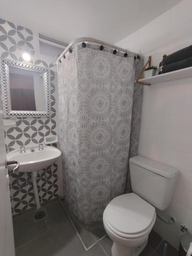 a bathroom with a toilet and a sink and a mirror at Apartment City Heart in Mendoza