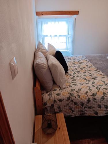 a bedroom with a bed with pillows and a window at Recanto da Pedra in Linhares