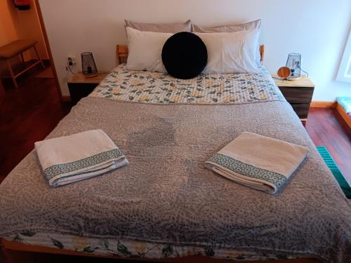 a bedroom with a bed with two towels on it at Recanto da Pedra in Linhares