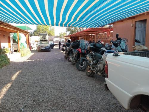 a group of motorcycles parked under a blue canopy at La Casa del Sol Naciente in San Pedro de Atacama