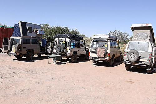 a group of vehicles parked in a dirt field at La Casa del Sol Naciente in San Pedro de Atacama
