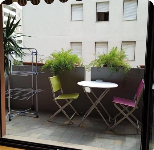 un patio con tavolo, sedie e un edificio di Appartamento Costantini a Pordenone