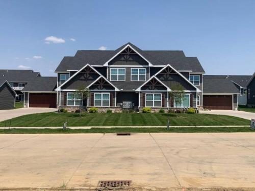 a large house with a large driveway at Modern 3-bedroom condo with gas fireplace in Bettendorf