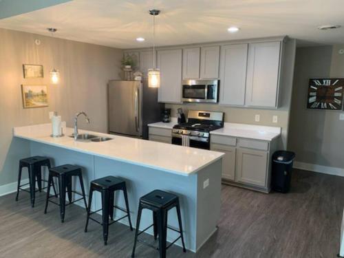 una cocina con una gran isla con taburetes de bar en Modern 3-bedroom condo with gas fireplace, en Bettendorf