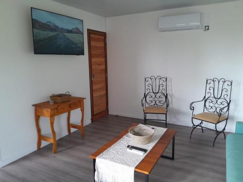 a living room with two chairs and a table at Cabaña Aike de Sierra de los Padres in Sierra de los Padres