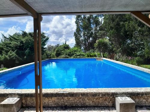 a swimming pool in a resort with blue water at Cabaña Aike de Sierra de los Padres in Sierra de los Padres