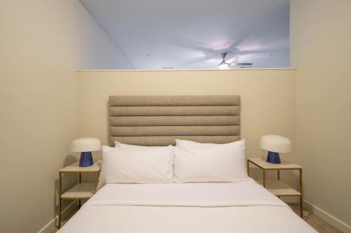 a bedroom with a white bed with a ceiling fan at CozySuites MusicRow Astonishing SDO with free parking 08 in Nashville