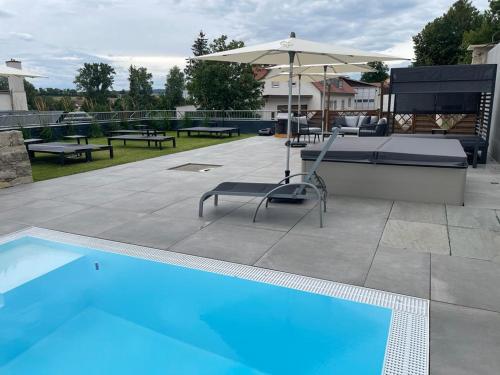 einen Pool mit einem Tisch und einem Sonnenschirm in der Unterkunft Land-gut-Hotel Landgasthof zur Rose in Ehingen