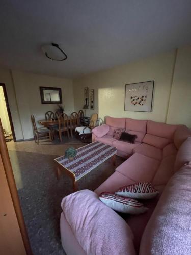 een woonkamer met een roze bank en een tafel bij Benidorm in Villajoyosa