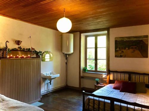 Maison des Séquoias - Parc 1 hectare- في Veyrac: غرفة نوم بسرير ونافذة ومغسلة