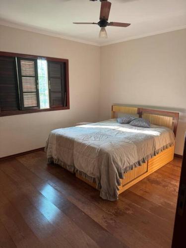 Schlafzimmer mit einem Bett und einem Deckenventilator in der Unterkunft Chácara Alvorada - Conchal in Conchal