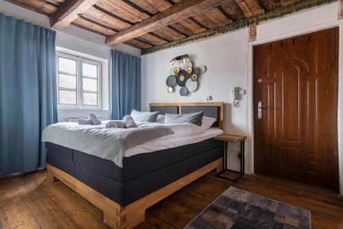 a bedroom with a large bed with blue curtains at 20 seconds to Charles Bridge in Prague
