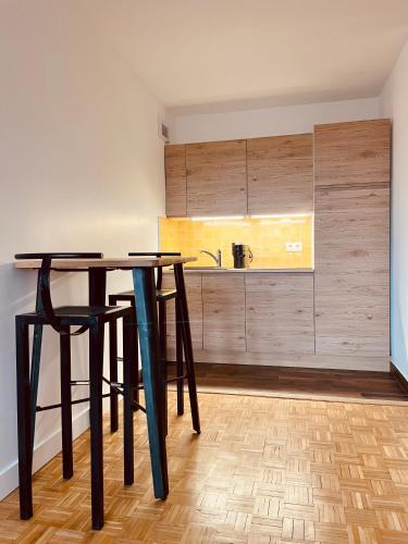 une cuisine avec une table, deux chaises et un comptoir dans l'établissement Vue imprenable sur la Tour Eiffeil, à Paris